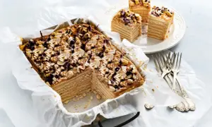 Pyszny snickers bez pieczenia z orzeszkami i polewą czekoladową. Idealny deser na każdą okazję.